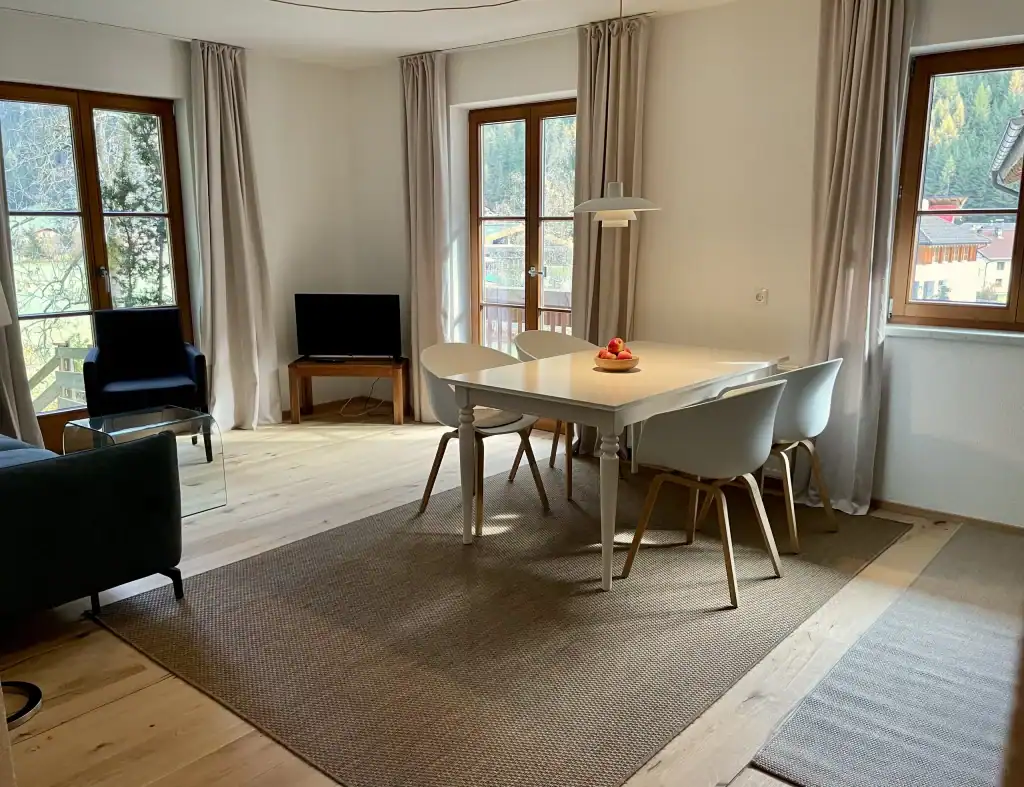 Moderne Wohnung mit hellem Wohnzimmer, Essbereich und großen Fenstern für viel Tageslicht.