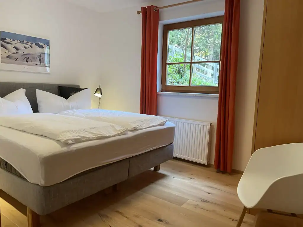 Gemütliches Schlafzimmer mit Blick auf den Garten, viel Tageslicht, moderner Komfort, ruhige Atmosph.