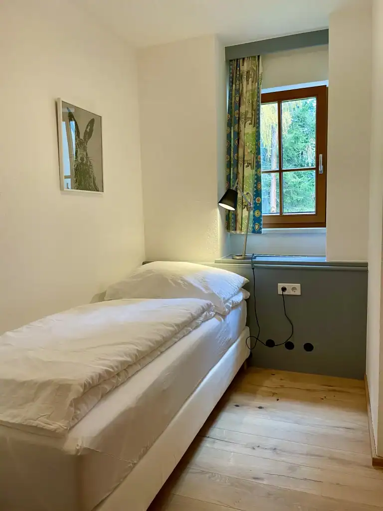 Gemütliches Schlafzimmer mit Fenster, Tageslicht und moderner Einrichtung für erholsamen Schlaf.
