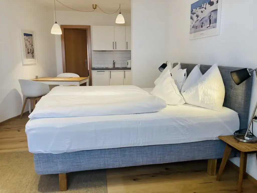 Modernes Hotelzimmer mit gemütlichem Bett und Küchenbereich.
